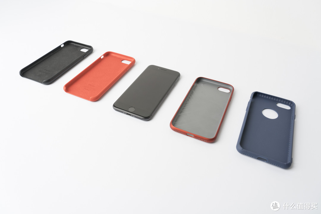 ↑iPhone 8和几个手机套：苹果皮套和硅胶套，国产牌子套，白菜套