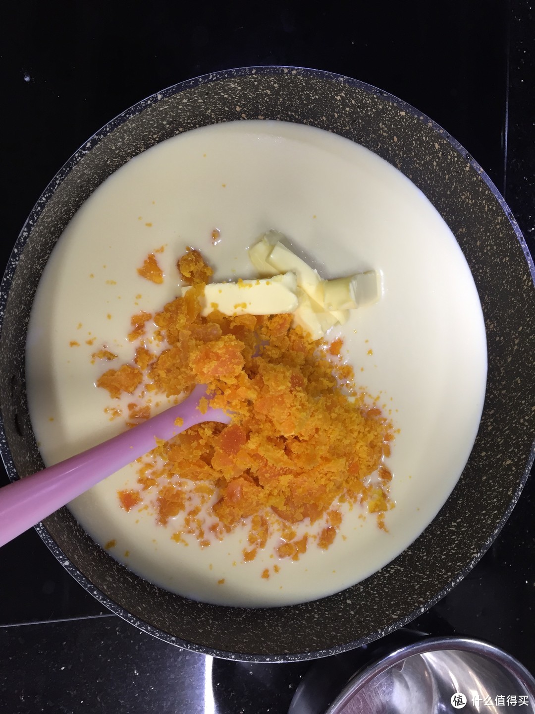 混合液体倒入平底锅中加入咸蛋黄末（可以过筛提高细腻度）和黄油，小火翻拌
