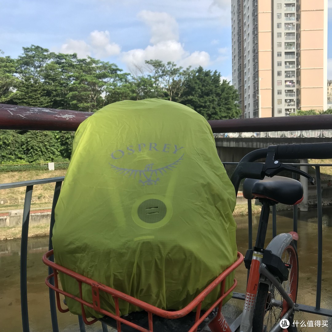 拿到户外套上防雨罩，大小适中，中间的圆形状为尾灯挂载点。Osprey的标识和字母都有反光设计。很多人吐槽O记的防雨罩都是这个绿色，我觉得安全考量是一个重要因素，这种黄绿色在夜晚以及野外都有很高辨识度，安全性要更高一些。