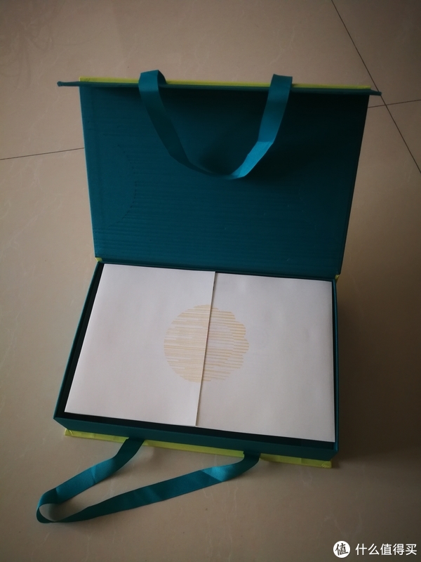 打开盒子，上面覆盖着包装纸，合起来是月饼的形状