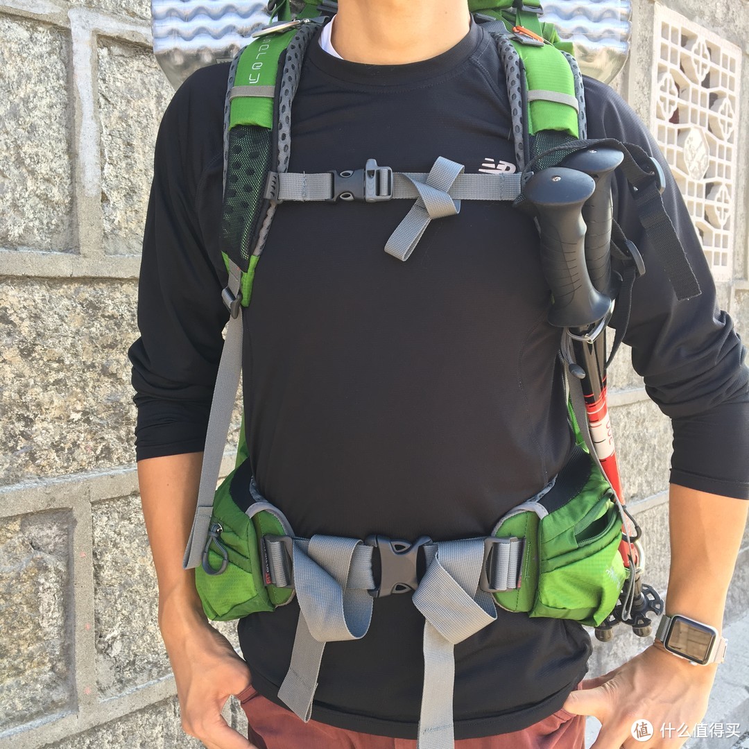 正面的效果如图，登山杖外挂系统也算是Osprey我很喜欢的一个设计了。胸扣自带求生哨，依然撞色配置。腰带对精瘦的我来说真是超级长了，腰带的绿色部分是可以自己根据需求调节长短的。腰包大小足够同时放入我的小米充电宝+iP7。