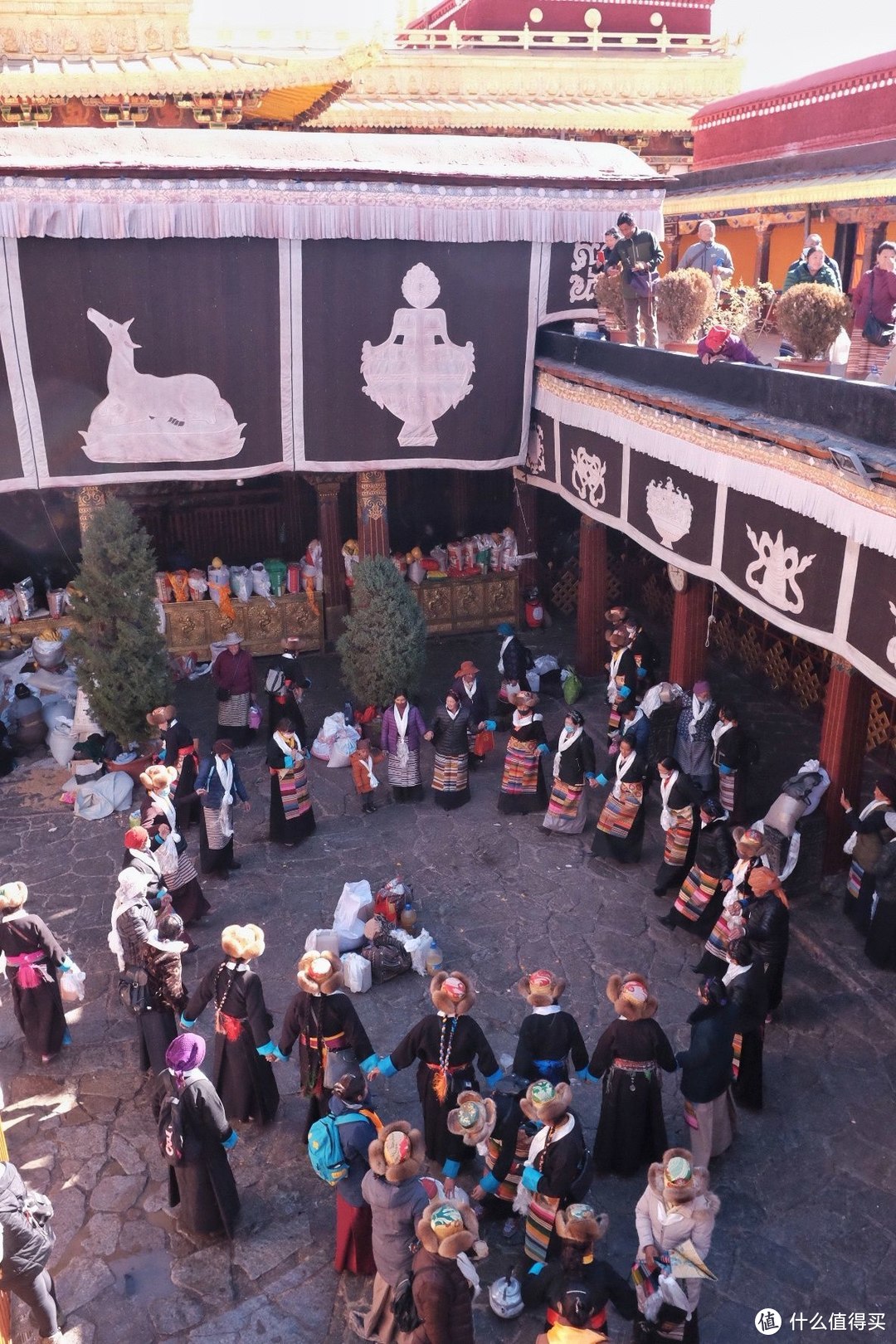 身着盛装的藏族女子，在大昭寺的内院绕着贡品跳舞。