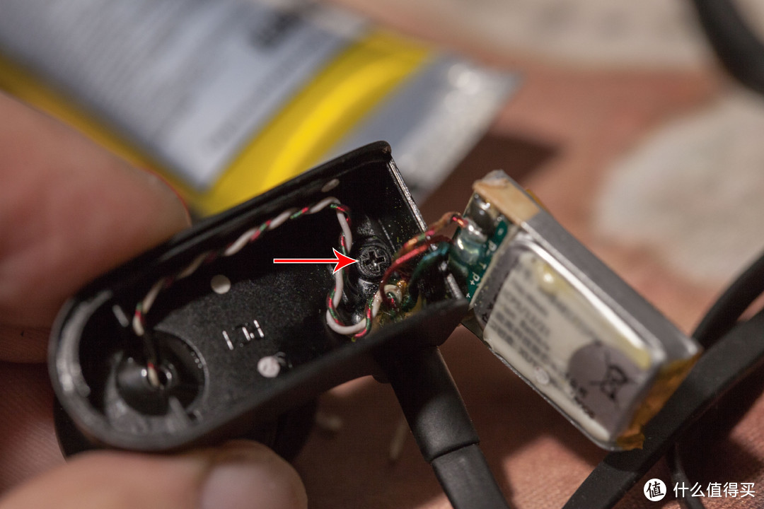 把电池拿进来就能看到固定耳挂的螺丝了，盘它。