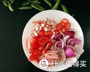 2.🍋🎀先将东北香米煮上，在这期间，把番茄、洋葱切块，蟹柳、培根、水果椒切段、并把浓汤宝冲兑好等会备用。