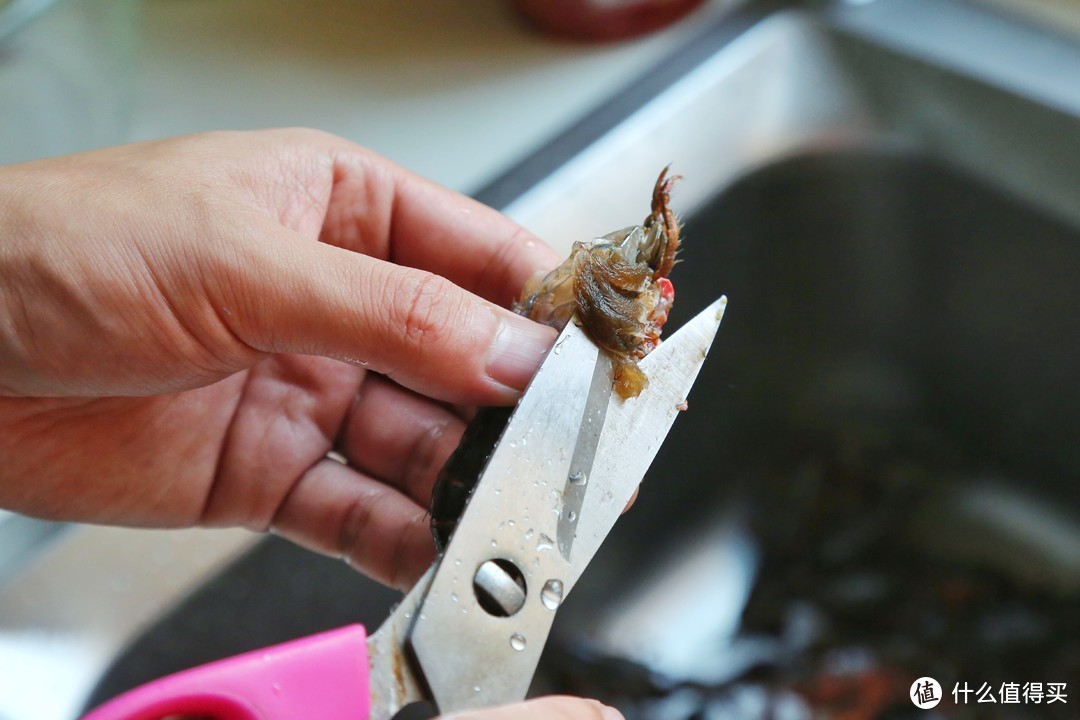 掀开小龙虾的头盖骨之后，用剪刀剪掉左右两侧的腮