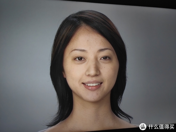 在人物的肤色显示上，55Q1表现的比较自然，图中的亚洲妹子的肤色没有被表现的过黄或者过白，但默认对比度下，细节表现存在磨皮现象，脸部的很多皮肤细节都丢失。