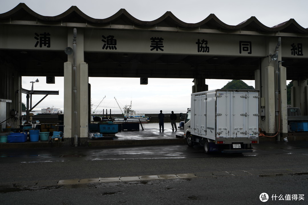 天晴了，内浦鱼协两个上班时间摸鱼看海的日本小哥。（我胆子太小，要是凑过去躲开这辆货车，角度再放低一点，这张照片可能就是一张不错的人文照了。）