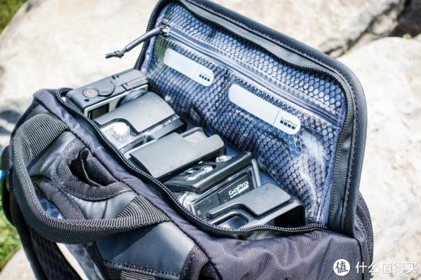 掀起的背包顶部有两个透明网袋，可以存储类似SD卡电池这些很容易搞丢的小东西