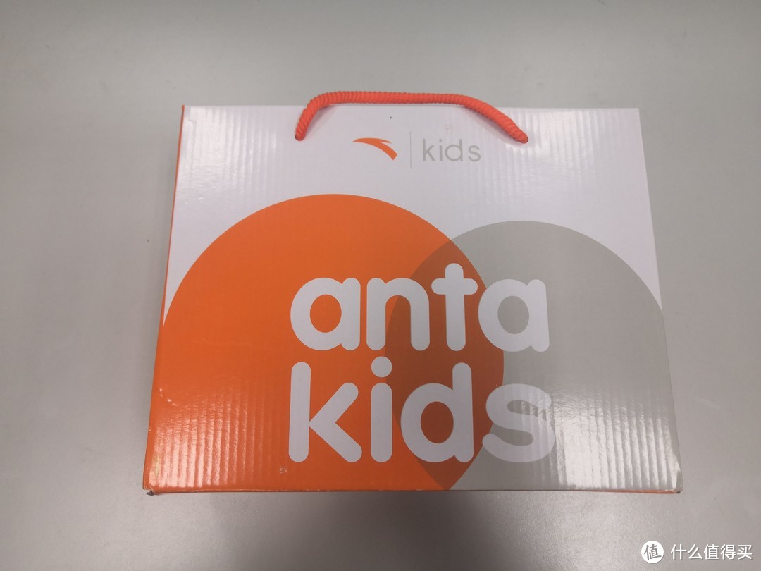 橙、灰、白三色鞋盒，anta kids，不知道图案是啥意思。