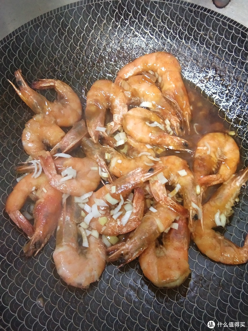 撒点蒜末出锅装盘码好虾后淋上锅中汤汁就这样香煎虾制作完成,希望你