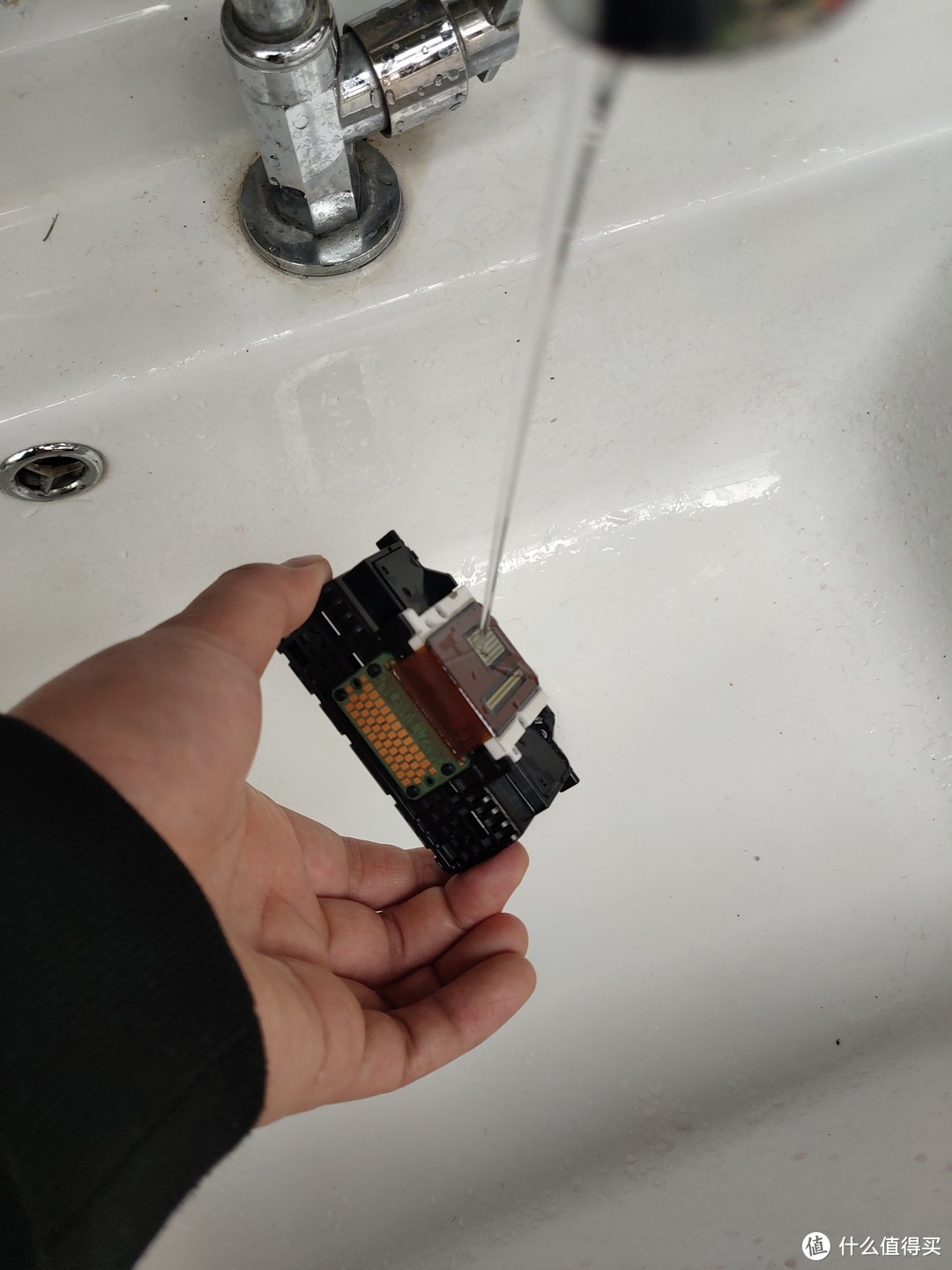 第二天拿清水冲洗，避免水流到那块电路板上，不过流上去问题也不大，看了一下只是一块板子，上边没有任何元件，擦干一般不会有啥问题。
