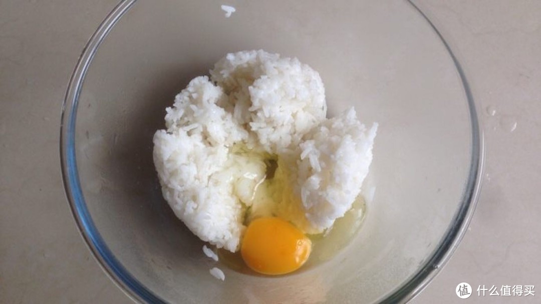 剩米饭加入鸡蛋，拌匀开来，让每一粒米饭都沾上蛋液