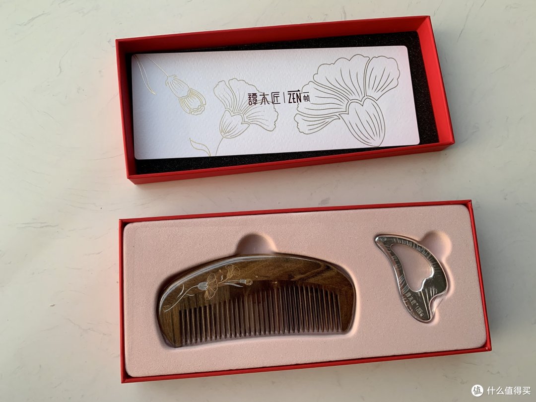 掀开盒子就看到一把木梳子和一块银色按摩板,都带着塑封盒子上的图案