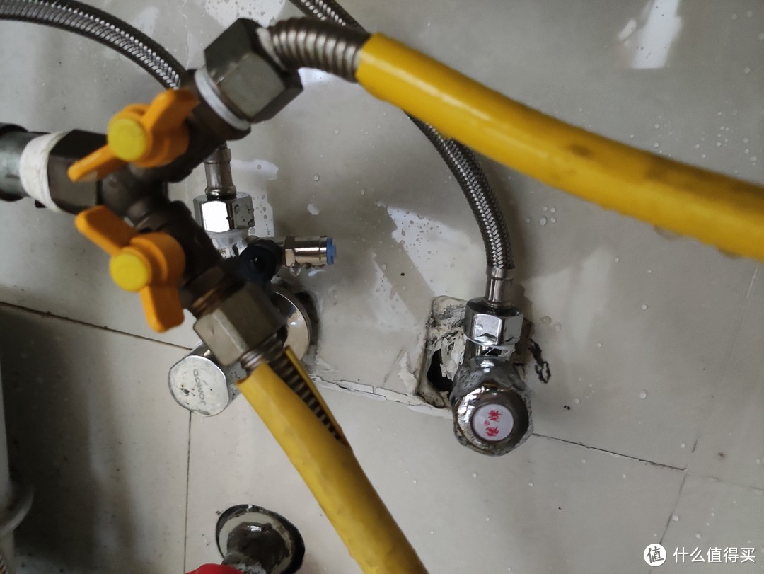 ▲ 黄色煤气管道后面是冷水管和热水管 在冷水管上接入一个三通 作为进水器的入水口