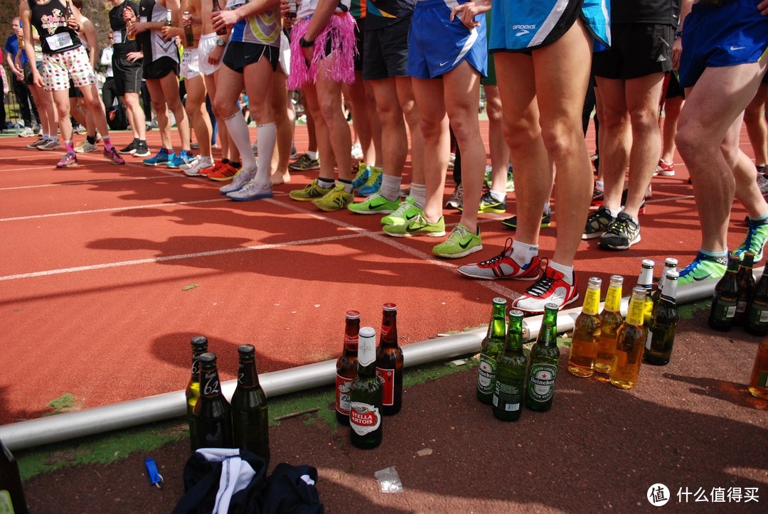 选手们先喝完一瓶开始起跑，赛道旁摆放着各自剩下的三瓶啤酒，接下来跑一圈喝一瓶。跑吐了还得再罚一圈