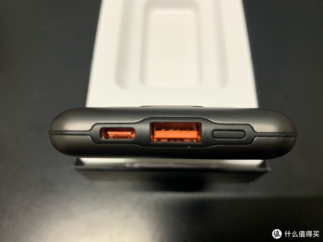 顶部有2个接口，橙色舌片，一个USB-A，一个USB-C和一个电源按键。