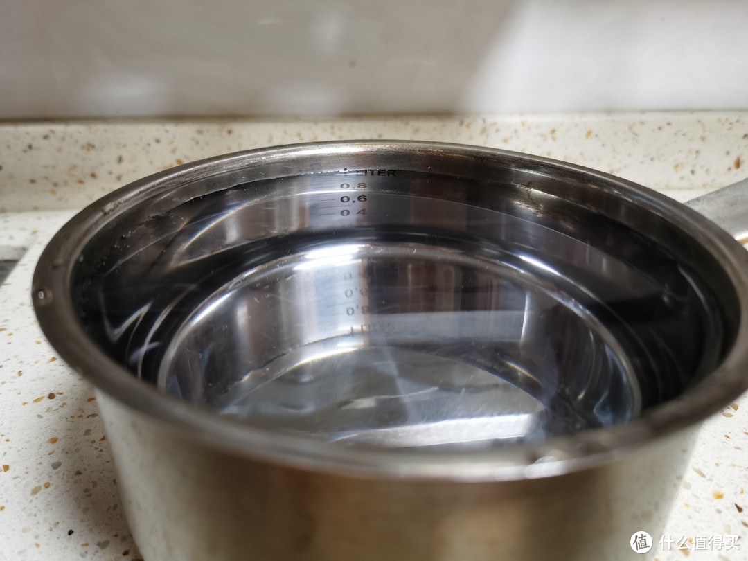 没有量杯量筒等容器，只好用这个带刻度的锅来接纯水测出水速度，刚好1升的量程，这个测量方法会有误差不会很精确，但可以作为参考