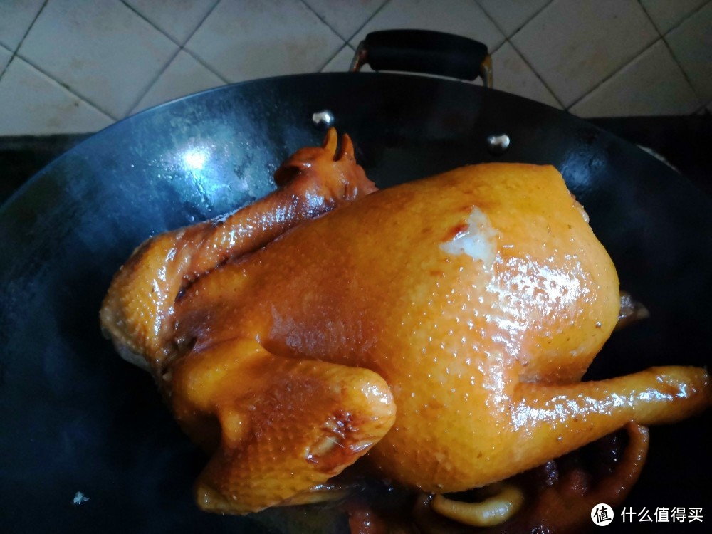 焖十分钟后，用炒勺再将汤汁浇在鸡身上，这步是让鸡吸味上色均匀，见鸡皮颜色已经比刚才要深一些了，浇上几分钟以后翻转身再浇一会，注意！用鸡脚垫锅底，把鸡身挂起，防止鸡皮粘锅，不然鸡皮会破烂，盖上锅盖，继续小火焖十分钟。