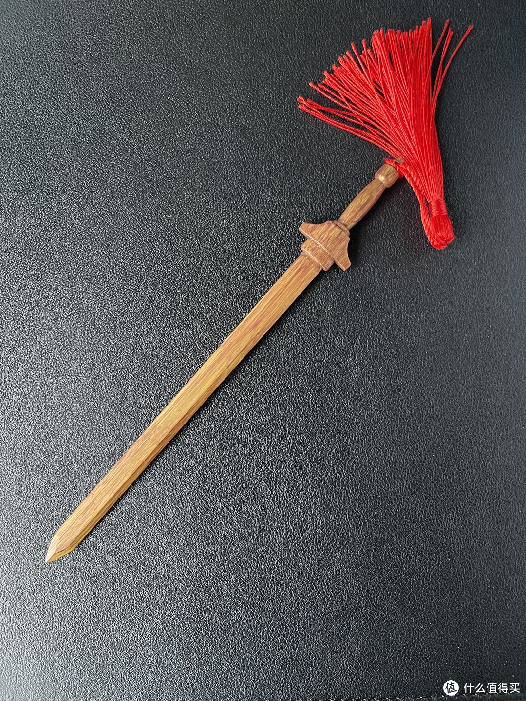 逍遥佩剑，跟官图几乎没有差距，剑身的木色纹理也很逼真，但是，它是一把锌合金武器，拿在手里沉甸甸的，很出戏。