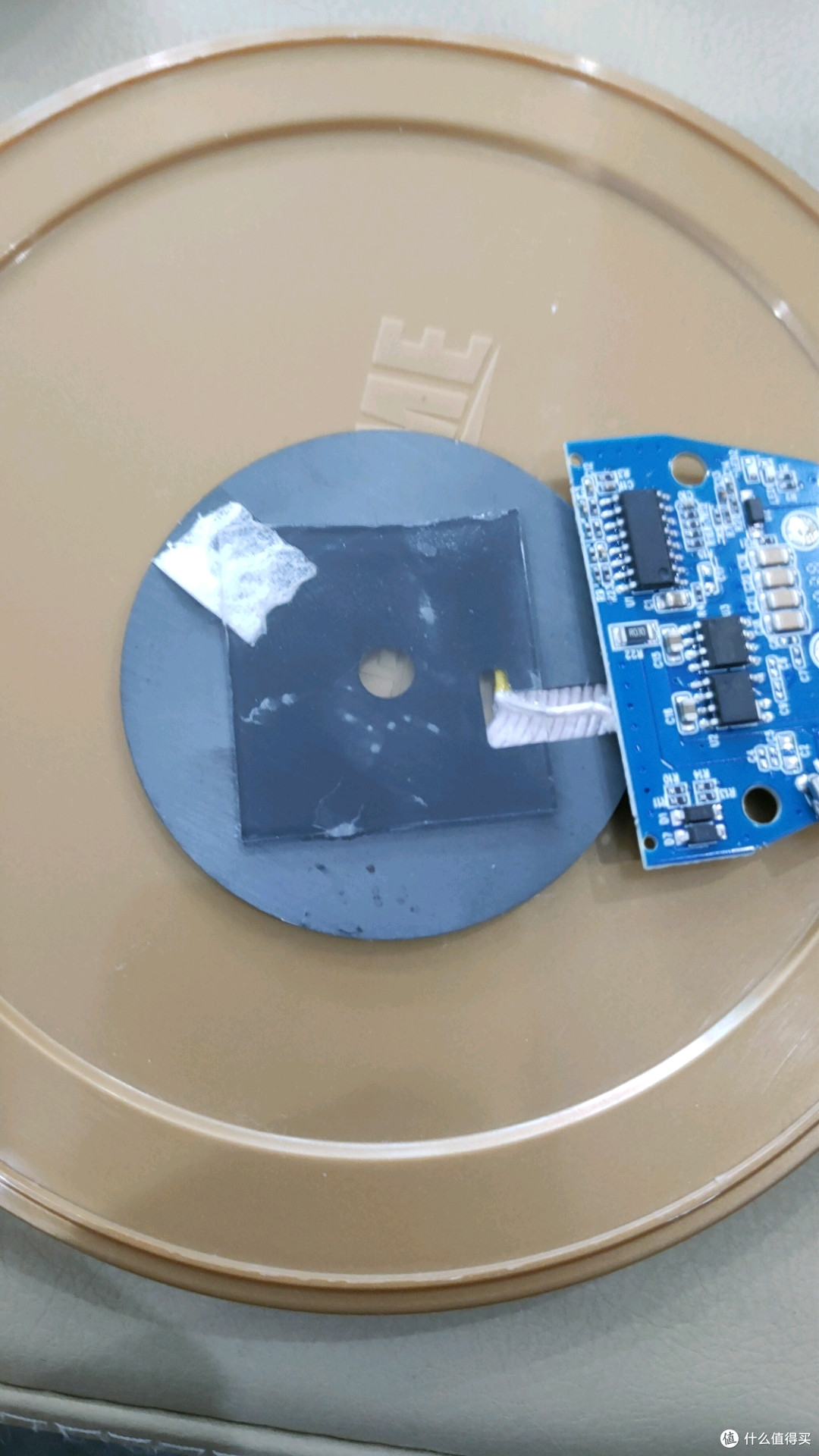 剪一块大小合适的纳米胶贴无线充电模块背面，然后贴盖子上