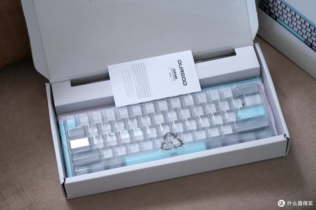 打开包装盒,键盘使用透明塑料防尘罩加以固定保护,随机配件则包括了