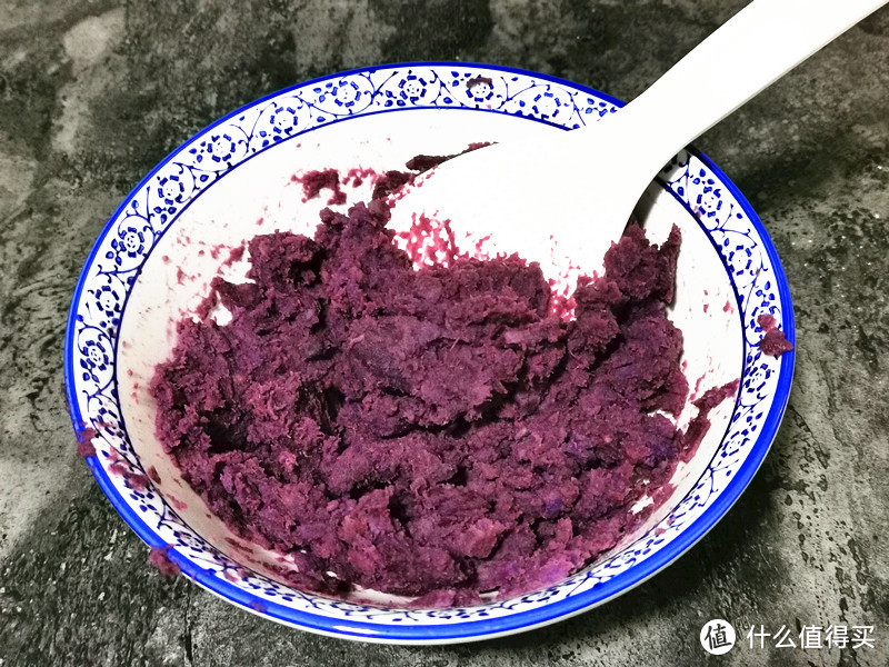 把紫薯泥倒入大碗中，趁热加入白糖拌匀，用铲子按压成泥，尽量按压的细腻一些；
