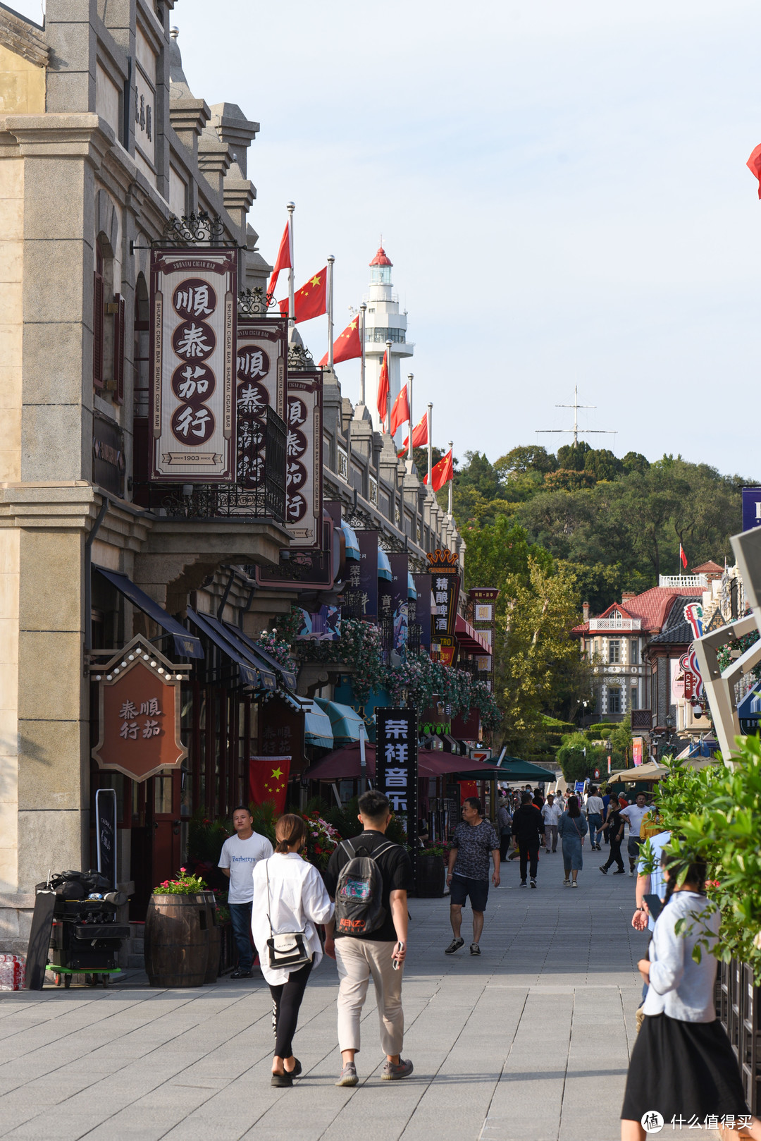 朝阳街远处可以看到烟台山上的灯塔，街上大部分门面以商店，餐厅为主，还有一家米其林二星餐厅，Jol Robuchon。