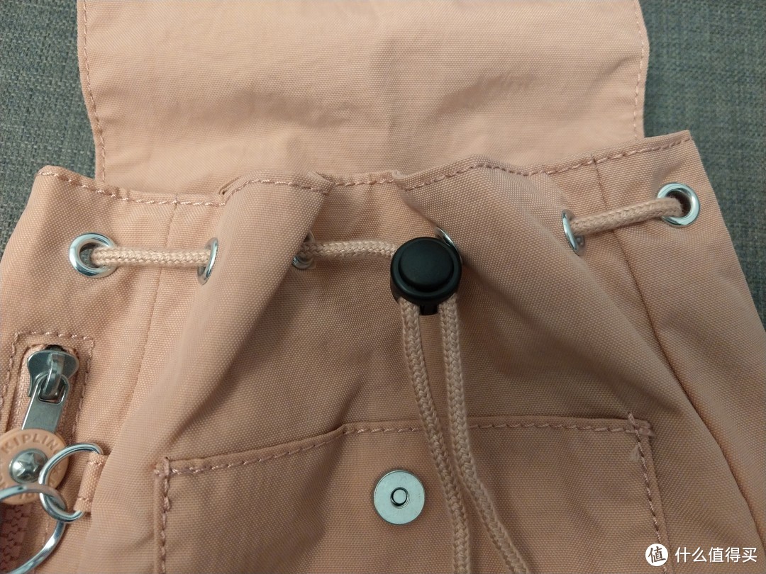 这个抽带的黑色按钮看上去好违和，包包前面口袋的缝合处线头也挺多的
