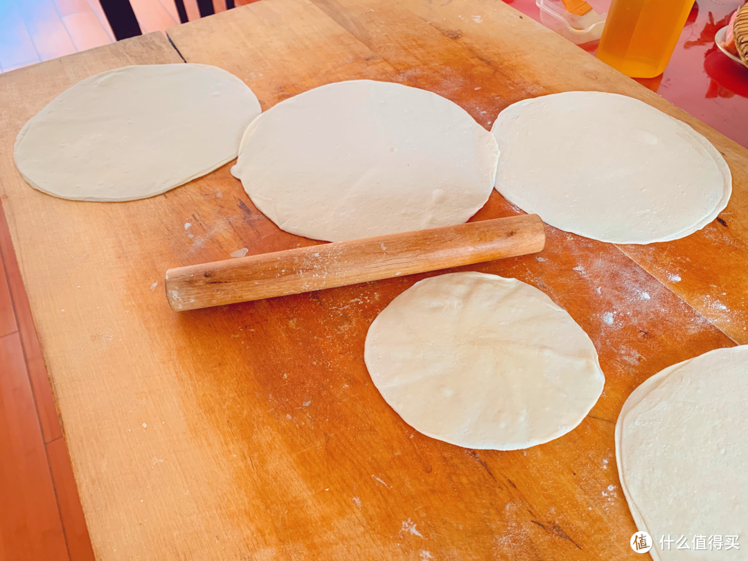 面粉和成面团，不需要发面，分成大小均等的面团，用擀面杖擀成圆 一面涂抹一点色拉油 ，两张对在一起 继续把面饼擀成更大的圆。