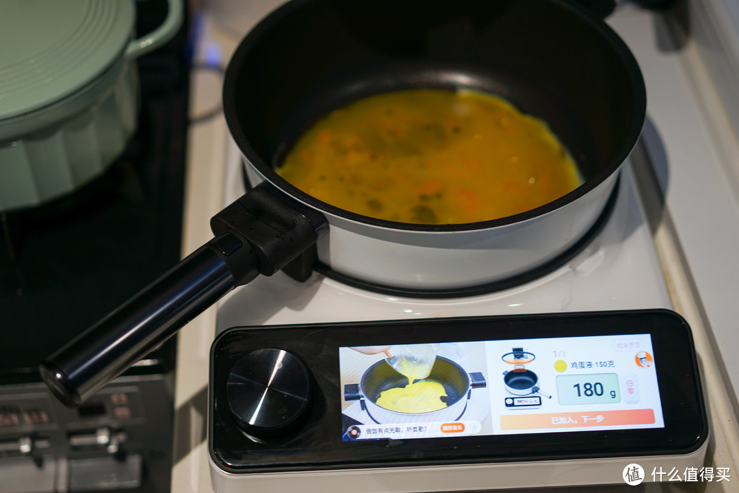 锅把油加热后，会提示加入鸡蛋液，同时自动打开锅盖，清零秤盘