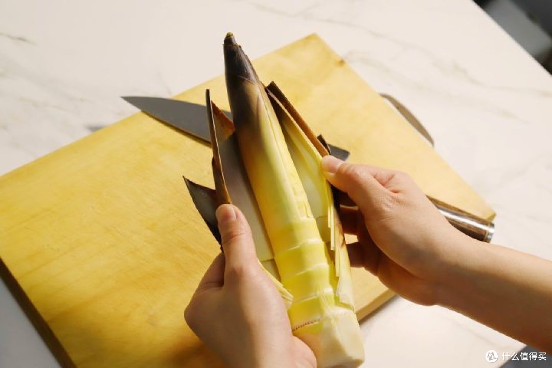 春笋竖着划一刀,剥壳,切去根部老的部分弃之,嫩间部分切滚刀.