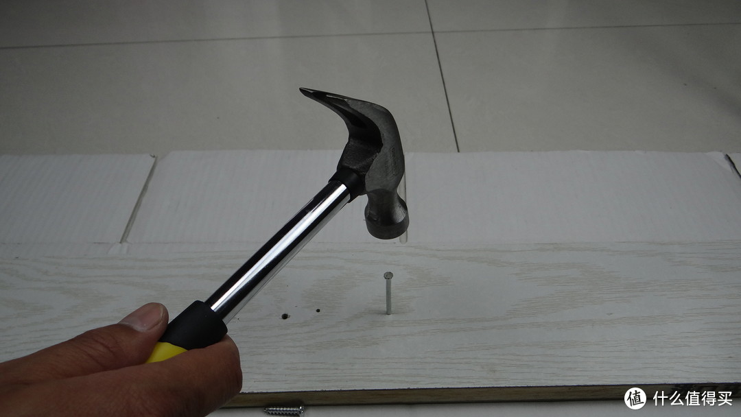 羊角锤和水泥钉配合在一起，不用费劲就可以轻松把水泥钉敲进木板里面。