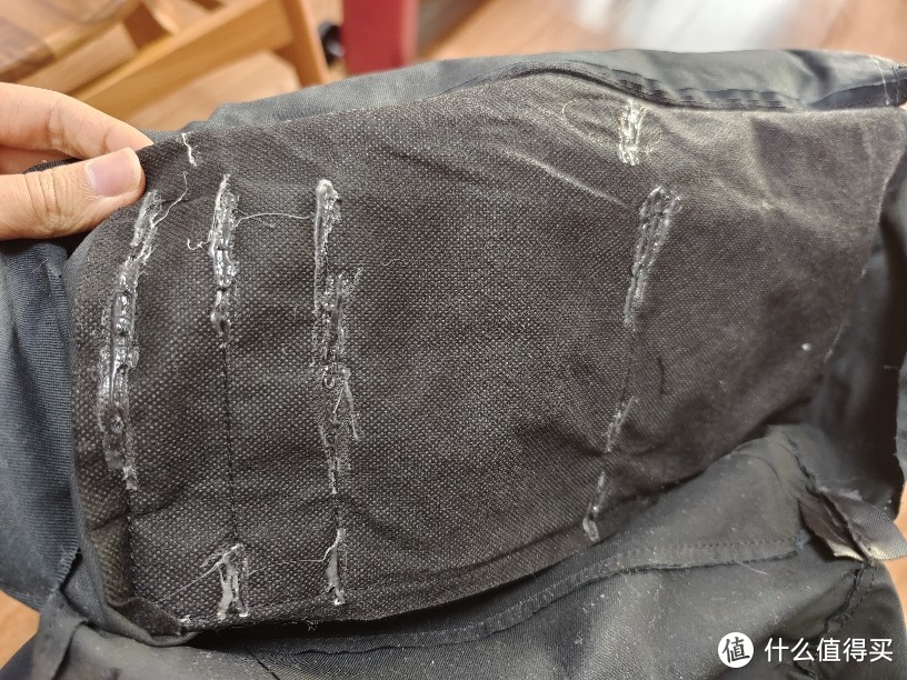 帆布小袋的背面，有纤维布补强，缝线的地方可能怕断，又加了点胶水