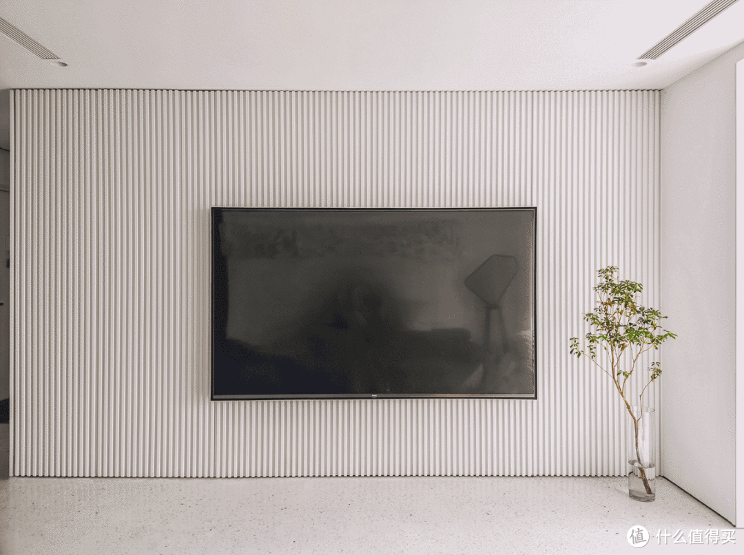 电视墙直接处理成白色烤漆格栅饰面，格栅有规律的纵向线条，利用这种饰面做柜子，可以达到一定隐形效果。