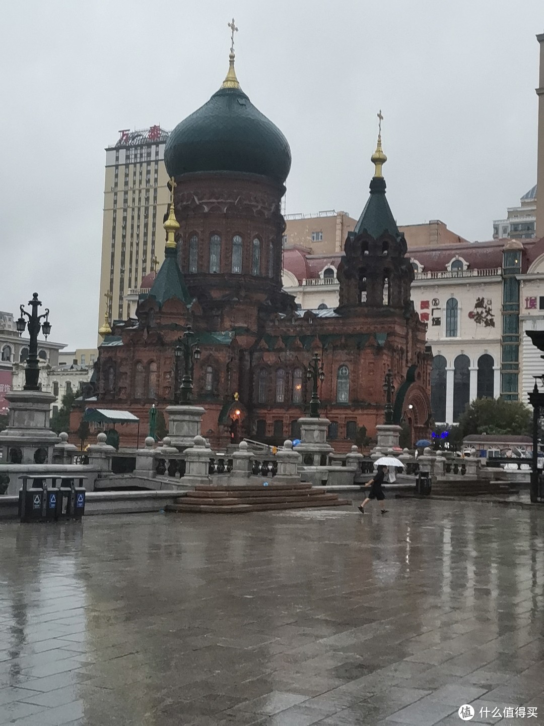 雨中的大教堂，旁边就是商场跟各种现代化建筑，